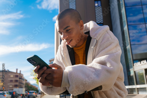 Young man using mobile phone while riding electric scooter in the city