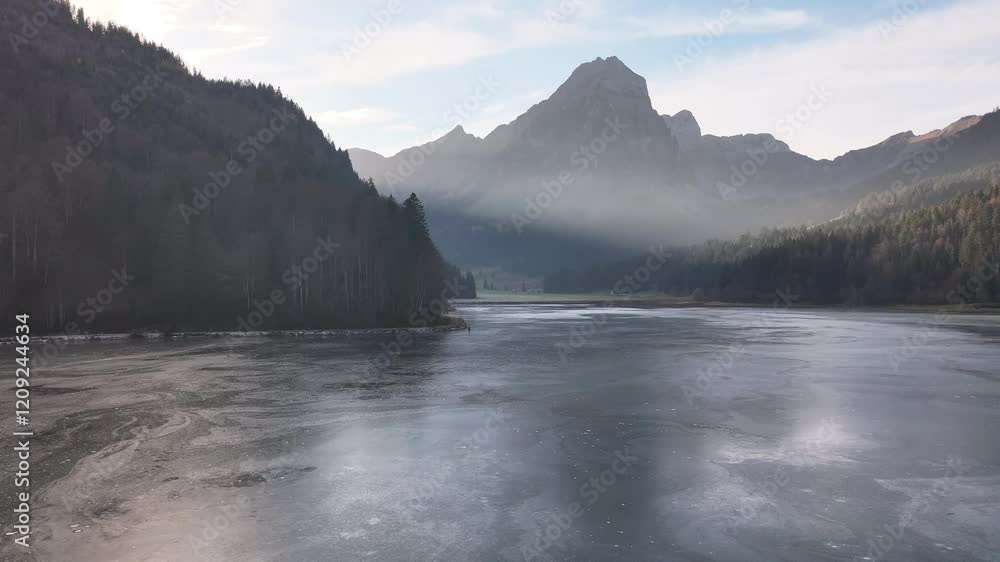 Calm frozen Obersee with mist and mountain backdrop in Näfels, Switzerland Calm frozen Obersee with mist and mountain backdrop in Näfels, Switzerland