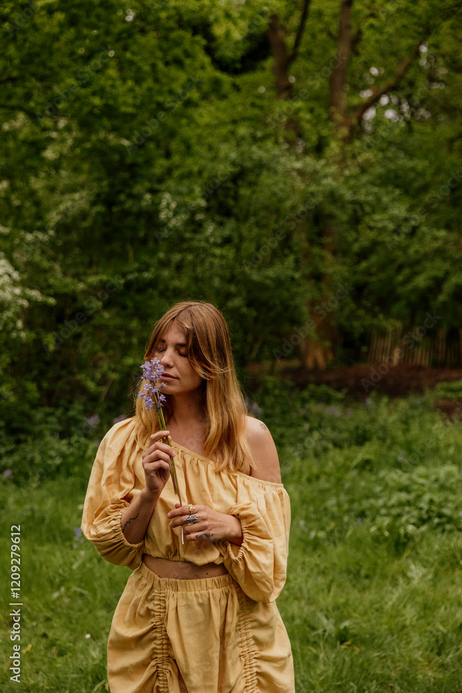 Woman in yellow linen dress surrounded by wildflowers Woman in yellow linen dress surrounded by wildflowers