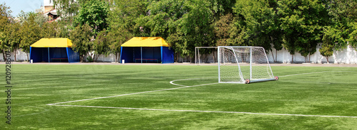 Vibrant soccer field ready for action under clear blue skies. Banner.