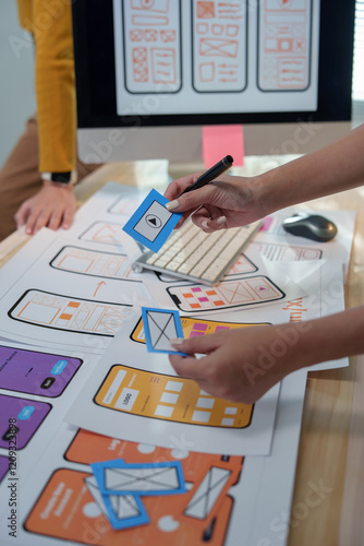 Fotografie Two ux designers collaborating on wireframing a mobile app, arranging blue cards