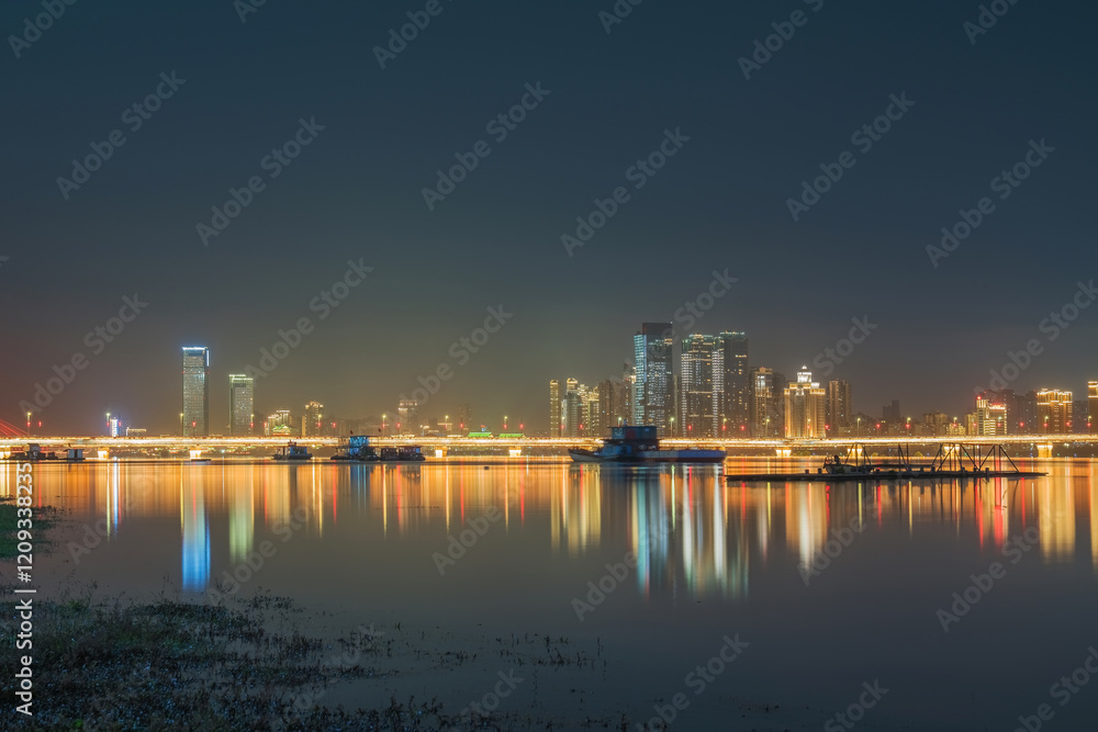 Fototapeta premium The urban skyline, hero bridge, and night view of Ganjiang River in Nanchang City, Jiangxi Province, China on April 1, 2024