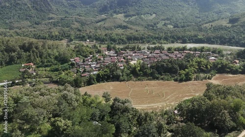 Wallpaper Mural Drone footage along a traditional wooden village of north Laos and the nearby countryside with rice fields and green vegetation. Camera is moving foward 2-3 Torontodigital.ca