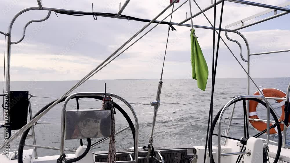 Yacht's Cockpit Framed by Twin Steering Wheels and Hanging Towel, Gazing Out at the Vast Ocean Under a Soft Grey Sky Moment of Calm on the North Sea Yacht's Cockpit Framed by Twin Steering Wheels and Hanging Towel, Gazing Out at the Vast Ocean Under a Soft Grey Sky Moment of Calm on the North Sea