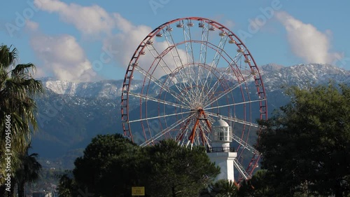 Ferris wheel against the backdrop of snow-covered mountains