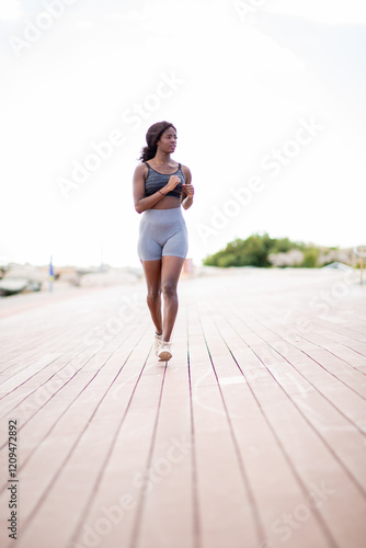 Full body african woman runs forward on boardwalk photo