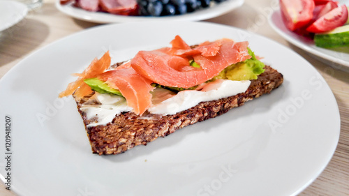 A nutritious open-faced sandwich with smoked salmon and avocado on rye bread symbolizes healthy eating and Scandinavian cuisine photo