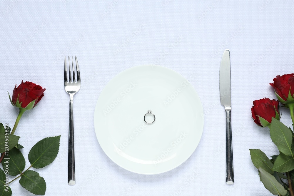 Engagement ring, rose flowers and tableware on white tablecloth, flat lay. Table setting for romantic dinner Engagement ring, rose flowers and tableware on white tablecloth, flat lay. Table setting for romantic dinner