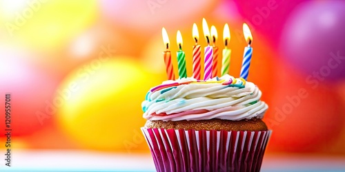 Birthday cupcake with colorful frosting and candles on a vibrant blurred background of yellow and pink balloons, placed centrally in the image. photo