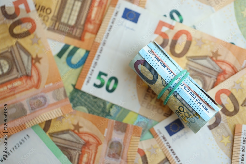 Roll of twenty euro currency bills lies on big amount of hundred and fifty euro banknotes Roll of twenty euro currency bills lies on big amount of hundred and fifty euro banknotes