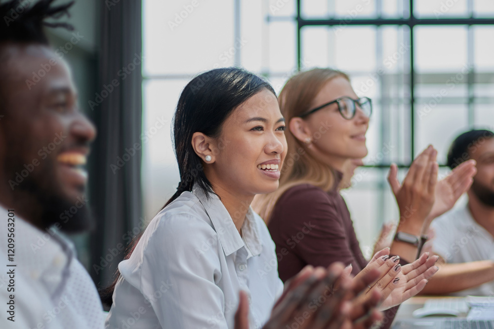 Multicultural colleagues sitting at desk near digital devices and documents during business meeting