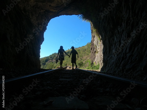 silhueta de casal caminhando em tunel  photo