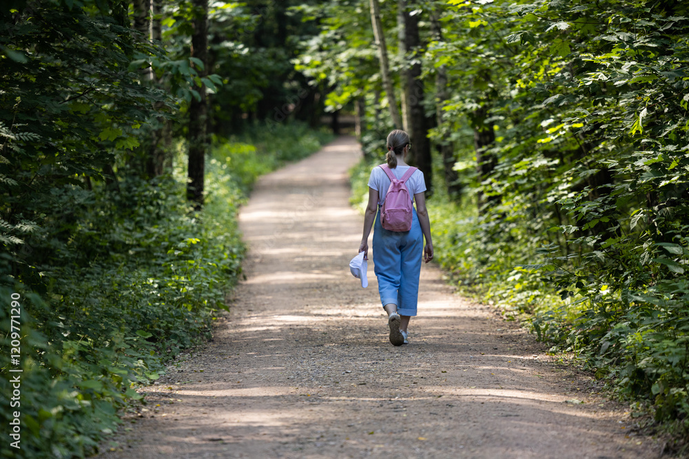Walking along a peaceful forest path surrounded by lush greenery on a sunny day Walking along a peaceful forest path surrounded by lush greenery on a sunny day