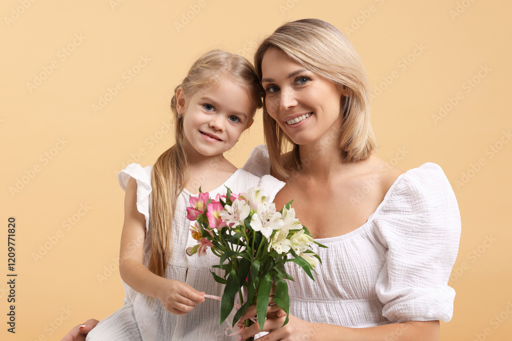 Happy woman with her daughter and bouquet of alstroemeria flowers on beige background. Mother's Day celebration Happy woman with her daughter and bouquet of alstroemeria flowers on beige background. Mother's Day celebration