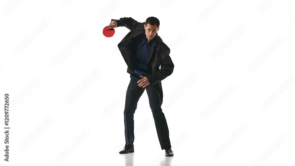 Man in black suit holding red ping-pong paddle in dynamic stance, representing agility and focus against white studio background. Concept of business, work-life balance, leadership, multitasking. Man in black suit holding red ping-pong paddle in dynamic stance, representing agility and focus against white studio background. Concept of business, work-life balance, leadership, multitasking.