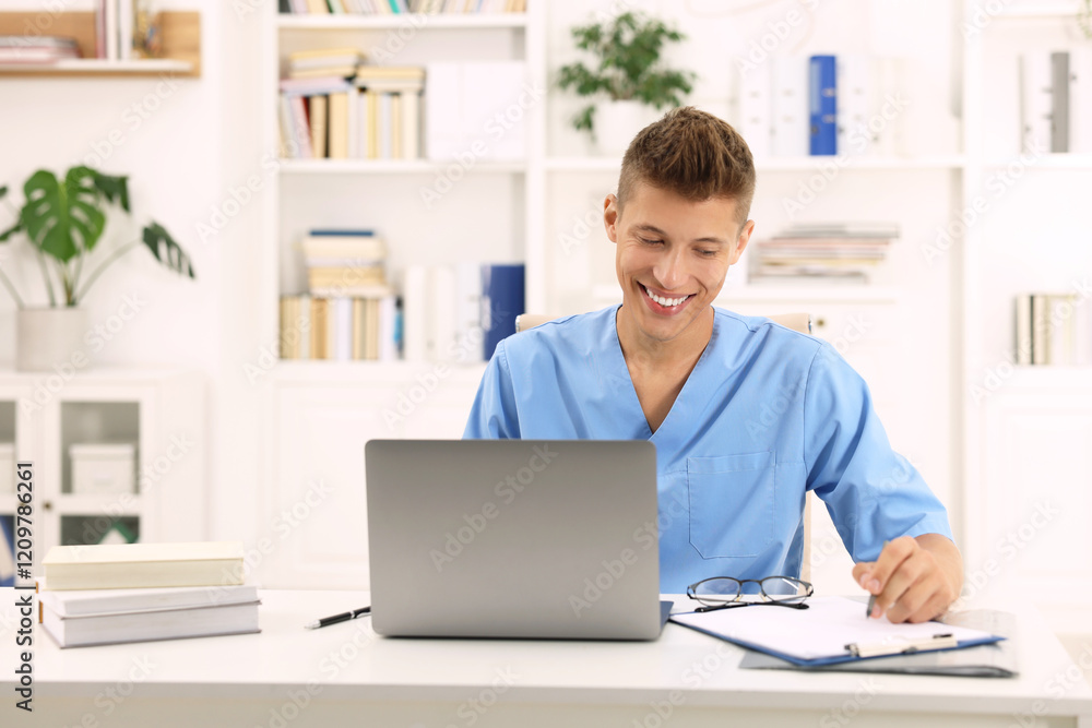 Medical student in uniform studying at table indoors Medical student in uniform studying at table indoors