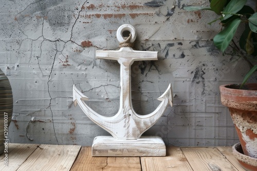 Decorative white wooden anchor standing on a wooden shelf against a gray cracked wall photo