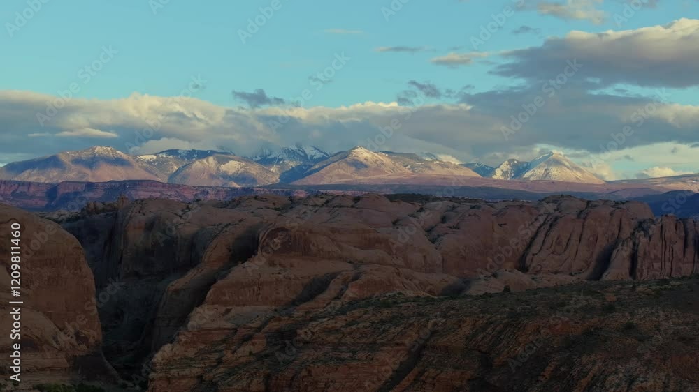 A view of rocky canyons with snow-capped La Sal mountains under a bright blue sky A view of rocky canyons with snow-capped La Sal mountains under a bright blue sky