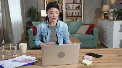 Young businesswoman freelance expatriate financial and digital marketing expert working at home in home office having video call on laptop computer webcam. Internet opportunities global business