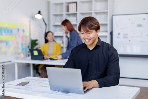 Smiling businessman working on a laptop computer in a modern office,doing finances, accounting analysis, report data pointing graph Freelance education and technology concept.	 photo