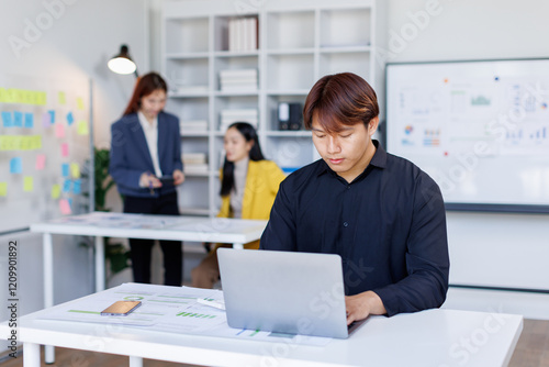 Smiling businessman working on a laptop computer in a modern office,doing finances, accounting analysis, report data pointing graph Freelance education and technology concept.	 photo