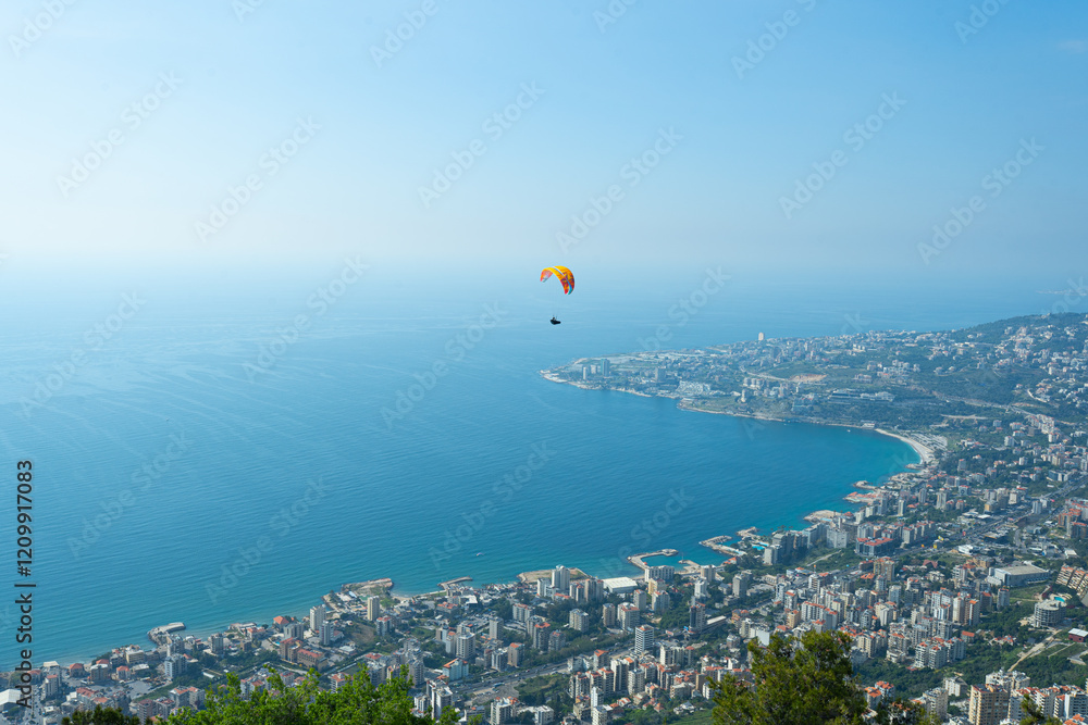 Fototapeta premium A breathtaking paragliding experience above Beirut, showcasing the city, sea, and historic sites. Adventure tourism, sports marketing, and travel promotions.