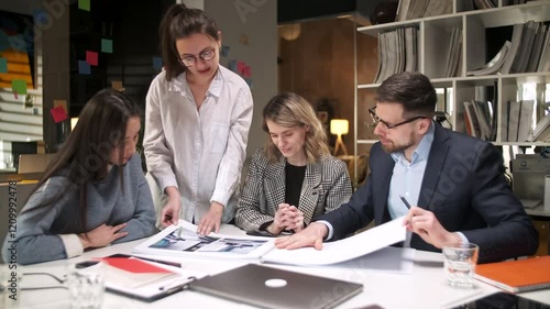 Colleagues And Clients Talking Strategy With Project Magazine. In Creative Office Productive Coworkers Standing At The Table For Company Meeting. Teamwork And Scial Concepts photo