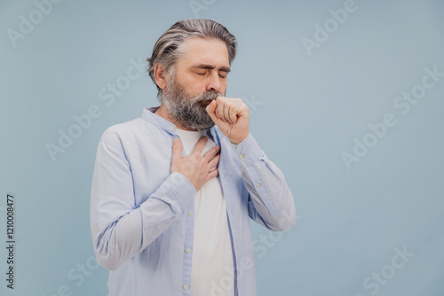Принти на полотні Senior man suffering from cough and chest pain on blue background