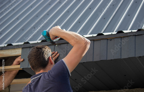 Man Installing Roof Panels with a Drill
