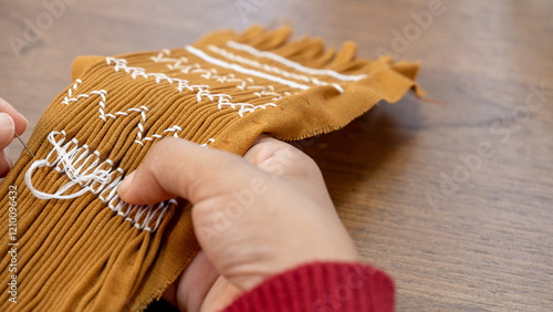 Artisan's Skilled Hands Embroider Pleats for a Smocked Dress.