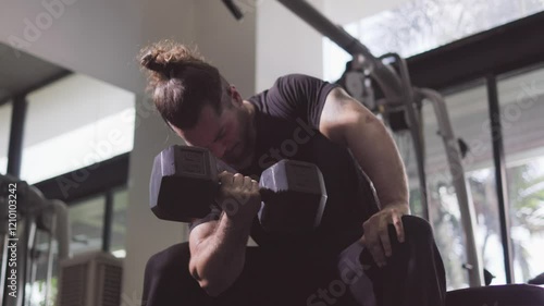 man exercising with dumbbells at gym, Dumbbell concentration curl