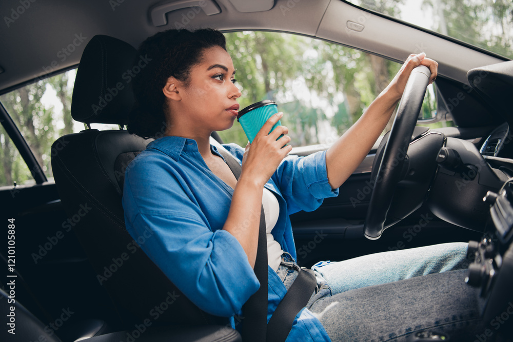 Naklejka premium Young woman enjoying a relaxing drive in the city sipping coffee with a smile