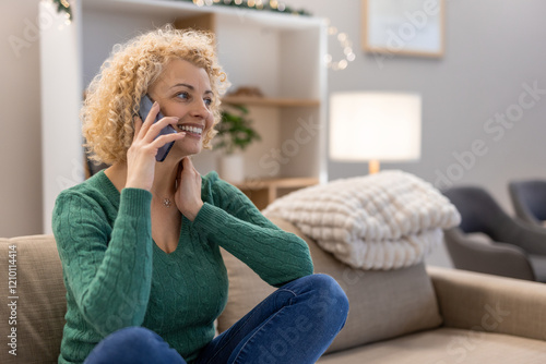 Happy Woman Talking on Phone While Sitting on Living Room Sofa photo