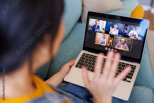 Woman having conference call while working remotely from home photo