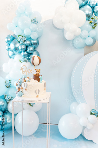 Decoration for first birthday of boy or a girl. Lot ballons, cake with cute bear. Free space for text. Celebration concept.