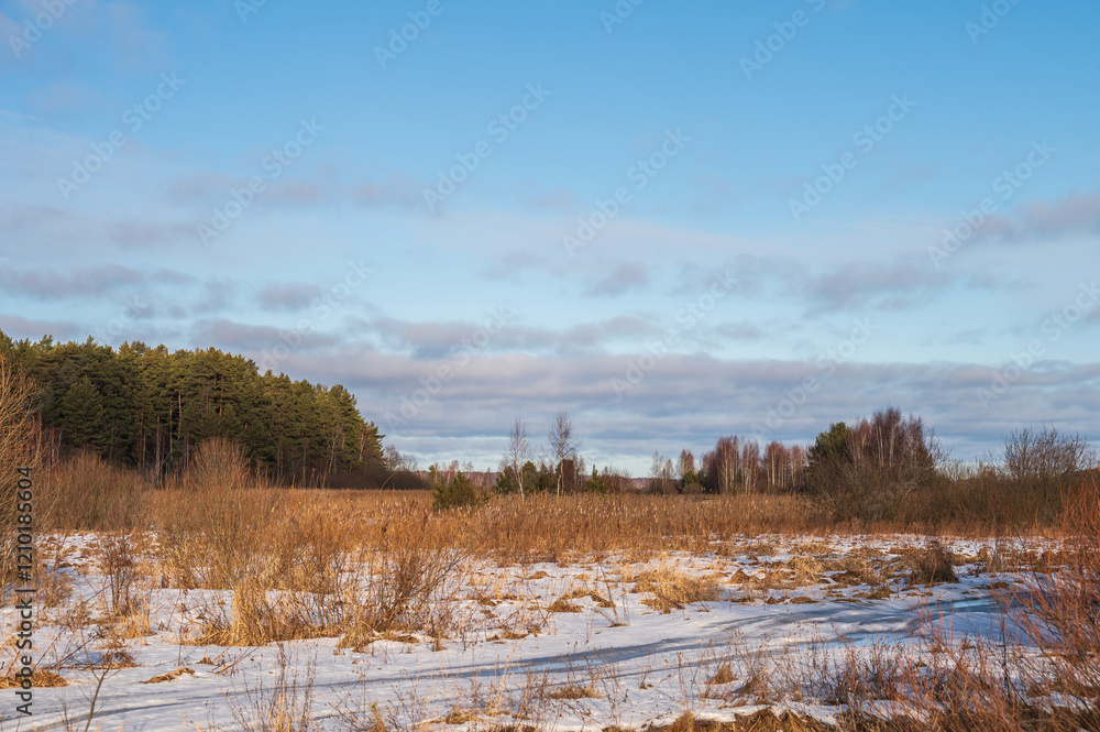 Aerial sunny winter landscape with large field, far forest under blue sky with white clouds. Natural winter background. Aerial sunny winter landscape with large field, far forest under blue sky with white clouds. Natural winter background.