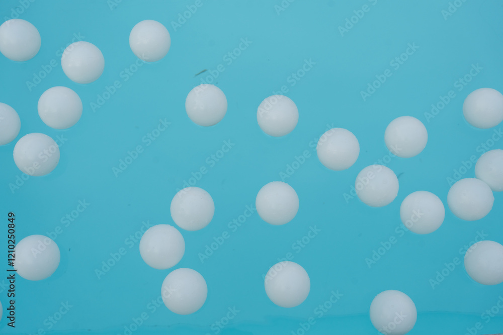 Many of white plastic balls floating on a swimming pool Many of white plastic balls floating on a swimming pool