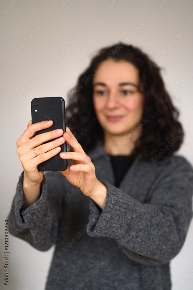 An isolated woman's portrait with a cell phone making selfie An isolated woman's portrait with a cell phone making selfie