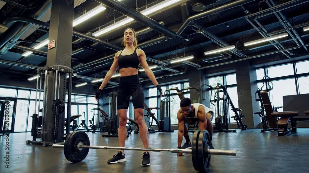 Focused athlete lifting weights in modern gym Focused athlete lifting weights in modern gym
