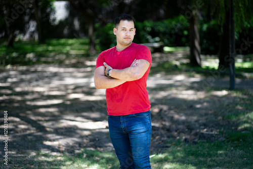 Quadro su tela Latin man with arms crossed in a park looking seriously at the camera