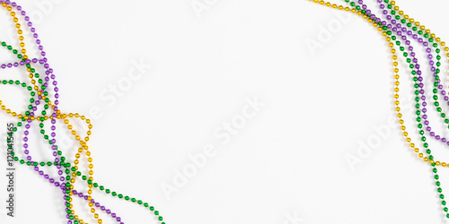 Mardi Gras beads composition background. Festive banner with colorful beads for Mardi Gras celebration on white background. Top view, flat lay.