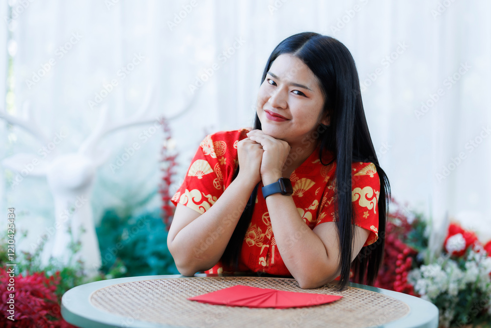 Portrait of happy asian woman relaxing wearing red cheongsam dress holding red envelopes at home in the living room indoor decoration for Chinese new year festival celebrate culture of china holiday