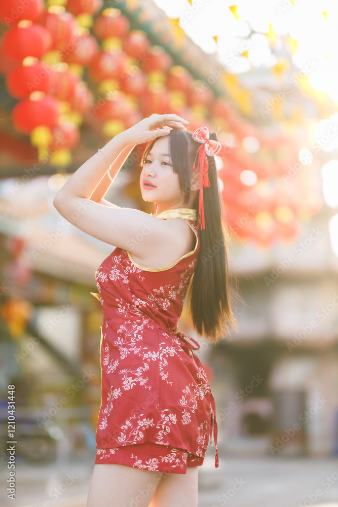 Portrait beautiful cute smiles Asian young woman wearing red cheongsam dress traditional decoration for Chinese new year festival celebrate culture of china at Chinese shrine Public places in Thailand