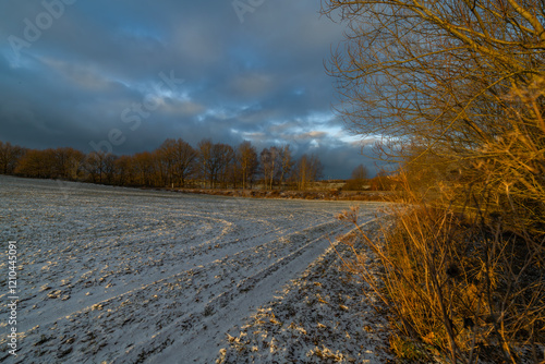 Sunrise with orange sun and winter snowy landscape near Nepomuk town photo