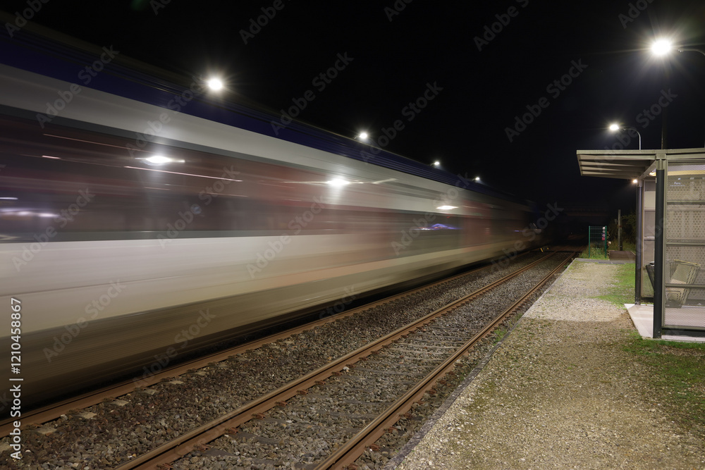 Naklejka premium Photo de nuit passage d’un train TER à la gare de Gauriaguet