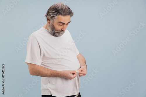 Φωτογραφία Senior caucasian man measuring his waistline with tape measure on blue backgroun