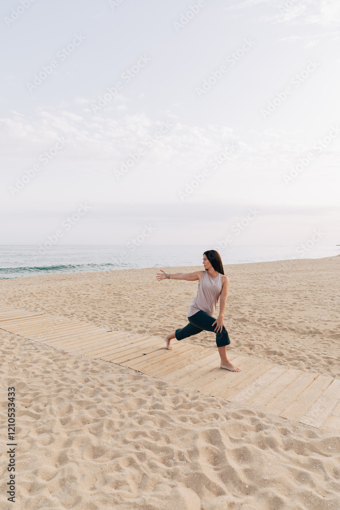 Woman practicing Yoga Pose on beach boardwalk Woman practicing Yoga Pose on beach boardwalk