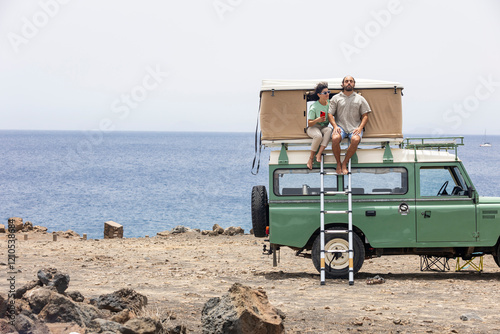 Blind man enjoying seaside view from motorhome rooftop photo