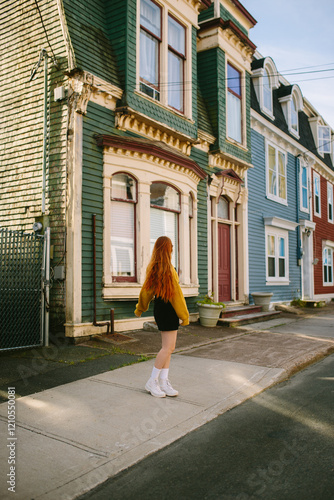 Anonymous young woman exploring colorful streets of St. John's photo