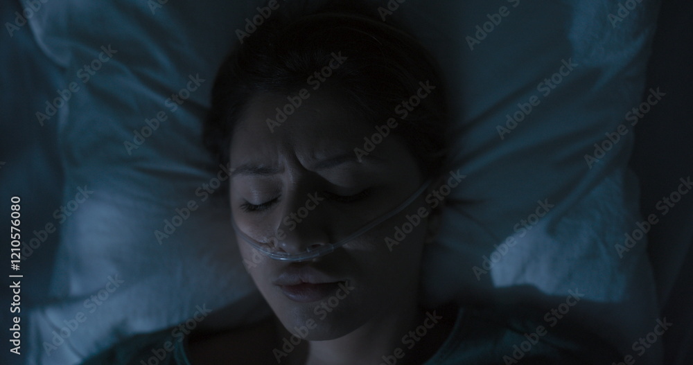Tired female patient in hospital ward with oxygen tube in nose awaken after sleep. Tired female patient in hospital ward with oxygen tube in nose awaken after sleep.
